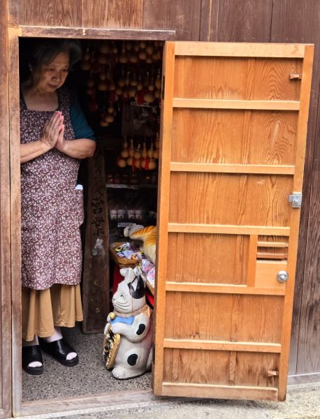 Woman praying in her shop - Kyoto, Japan